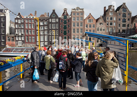 Gruppe von Touristen warten an einem Kanal Boot Touren Pier in der Altstadt von Amsterdam, Holland, Niederlande. Stockfoto