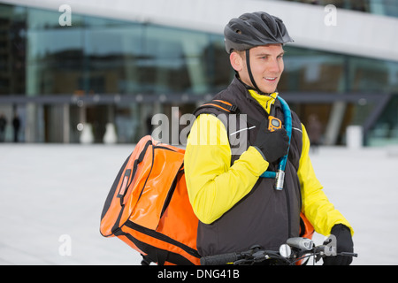 Männliche Radfahrer mit Lieferung Kuriertasche mit Walkie-Talkie Stockfoto