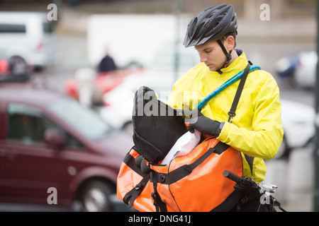 Junge männliche Radfahrer ins Paket Kuriertasche Stockfoto