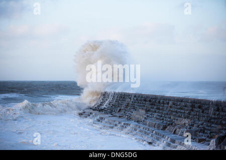 Aberystwyth, Wales, UK. 27. Dezember 2013.  Orkanartigen Winden batter die walisische Küste und bei Flut massive Wellen brechen sich am Meer front in Aberystwyth. Eine Welle bricht über und versteckt sich vor Ansicht groß Navigation Leuchtturm am Ende der Mole, die Einfahrt in den Hafen schützt. Bildnachweis: atgof.co/Alamy Live News Stockfoto