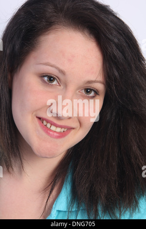 Eine schöne junge Brünette in einem blauen Hemd vor einem hellen farbigen Hintergrund in Nahaufnahme. Stockfoto