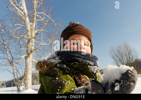 Ein Baby Boy halten Schnee Stockfoto