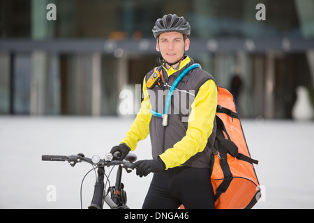 Junge männliche Radfahrer mit Lieferung Kuriertasche Stockfoto