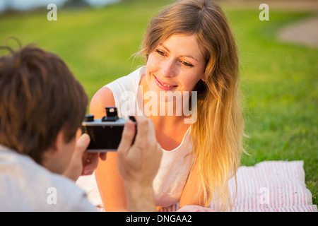 Paar Fotos von einander mit Retro-Vintage-Kamera auf Picknick Stockfoto