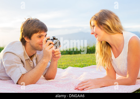 Paar Fotos von einander mit Retro-Vintage-Kamera auf Picknick Stockfoto