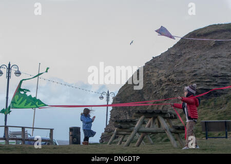 Aberystwyth, Wales, UK. 27. Dezember 2013. Junge Kinder profitieren Sie von den stürmischen Winden um ihre Drachen zu fliegen. Bildnachweis: Jon Freeman/Alamy Live-Nachrichten Stockfoto