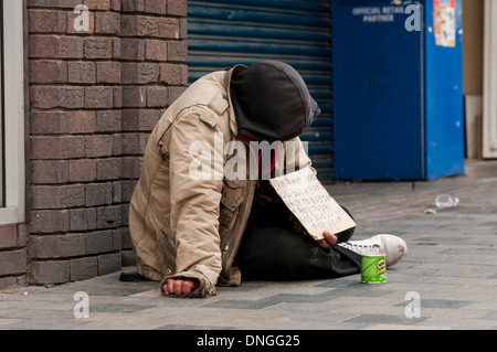 Obdachloser betteln auf Sauchihall Street in Glasgow, Schottland, Großbritannien. Er sitzt neben einem Shop, der geschlossen wurde. Stockfoto