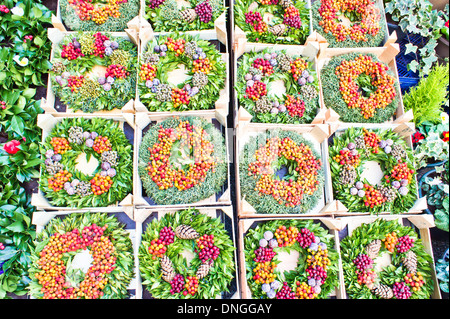 Bunte Weihnachtskränze zum Verkauf an einem Marktstand Stockfoto