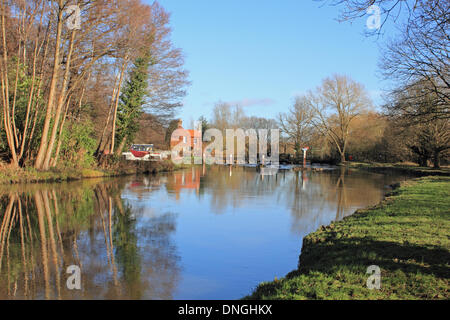 Die Wey-Kanal bei Ripley, Surrey, England, UK. 28. Dezember 2013. Nach den Stürmen in ganz Großbritannien über Weihnachten war Samstag einem milden und sonnigen Tag in Surrey. Das Wasser war ruhig, das Wehr bei Walsham Gates, mit festgemachten Hausboote und der Schleusenwärter-Hütte auf den Wey Navigation in der Nähe von Ripley nähert. Es gab Hinweise, die das Wasser wurde über die Banken und in angrenzenden Land hatte aber seit entschwanden. Bildnachweis: Julia Gavin/Alamy Live-Nachrichten Stockfoto