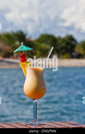 Pina Colada am Strand mit frischer Ananas und Kirschen garniert serviert Stockfoto