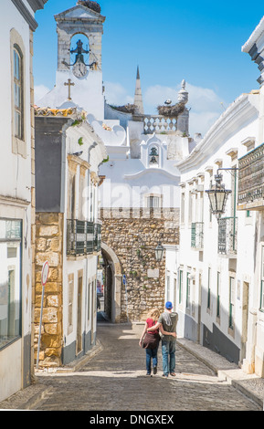 junges Paar auf einer Straße mit Kopfsteinpflaster in der Altstadt von Faro, Algarve, portugal Stockfoto