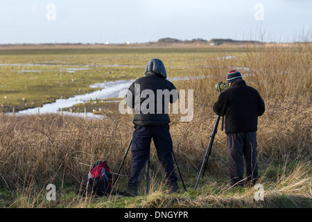 Zwei Männer, die ein digiscope am Wildlife Pond in Southport, Merseyside, Großbritannien, verwenden. Dezember 2013. Vogelbeobachter, Birder bei der Überwachung von Zugvogelarten im RSPB Marshside Reserve. Berichte legen nahe, dass einige Wasservögel und Wasservögel ihre Überwinterungsgebiete aufgrund der sich ändernden Wintertemperaturen in Europa nach Nordosten verschoben haben. Eine Änderung, die Auswirkungen auf ihre Erhaltung haben kann, weil Vögel weniger von den Reserven Gebrauch machen, die zum Schutz dieser Tiere bestimmt wurden. Viele nutzen die Lancashire WWT-Reserven, um sich auszuruhen und einige Wochen zu tanken, bevor sie auf ihrer Reise weitermachen Stockfoto