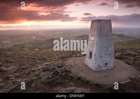 Der OS-Trig Punkt steht hoch auf dem Worcestershire Leuchtfeuer auf die Malvern Hills bei Sonnenuntergang. Stockfoto