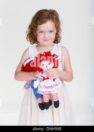 Raggedy Ann und Andy Kinder Spielzeug von jungen Mädchen mit roten Haaren gehalten. Stockfoto