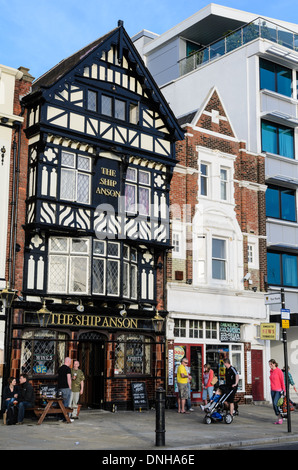 Typisch englisches Pub in schwarz und weiß (halb Fachwerkhaus)-Tudor-Stil, mit Kunden an einem warmen Sommertag draußen versammelt. Stockfoto