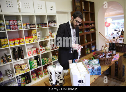 Rabbi Shmuel Havlin Etiketten koschere Milch, Frischkäse und Kräuterkäse von der Molkerei "Kruse Bauernhof Milch" in einem jüdischen Geschäft in Hamburg, Germany, 26. November 2013. Die kleine Molkerei behauptet, Deutschlands einzige Molkerei, die Käse, Hüttenkäse, Frischkäse und Milch nach den jüdischen Speisegesetzen der Kaschrut herstellt. Foto: Christian Charisius/dpa Stockfoto