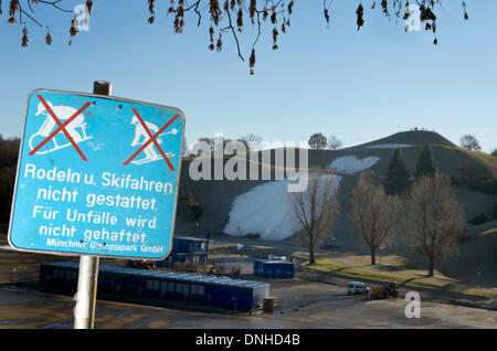 München, Deutschland. 30. Dezember 2013. Ein Zeichen Lesung "Rodeln und Skifahren sind nicht gestattet. Für Unfälle wird nicht gehaftet. Munich Olympic Park GmbH "steht auf dem Olympiagelände in München, 30. Dezember 2013. In den Rücken zeigen ein paar weiße Flecken der Schnee den Versuch, eine Skipiste für den Ski-Weltcup auf der Olympiaschanze zu schaffen. Der Parallelslalom FIS World Cup für 1. Januar 2014 geplant wurde aufgrund des warmen Wetters und Schneemangel abgesagt. Foto: PETER KNEFFEL/Dpa/Alamy Live News Stockfoto