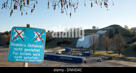 München, Deutschland. 30. Dezember 2013. Ein Zeichen Lesung "Rodeln und Skifahren sind nicht gestattet. Für Unfälle wird nicht gehaftet. Munich Olympic Park GmbH "steht auf dem Olympiagelände in München, 30. Dezember 2013. In den Rücken zeigen ein paar weiße Flecken der Schnee den Versuch, eine Skipiste für den Ski-Weltcup auf der Olympiaschanze zu schaffen. Der Parallelslalom FIS World Cup für 1. Januar 2014 geplant wurde aufgrund des warmen Wetters und Schneemangel abgesagt. Foto: PETER KNEFFEL/Dpa/Alamy Live News Stockfoto