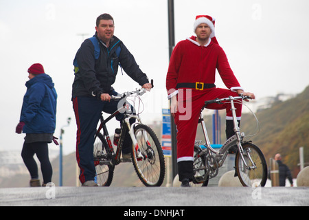 Santa und Freund mit ihren Bikes auf Bournemouth promenade am Weihnachtstag Stockfoto