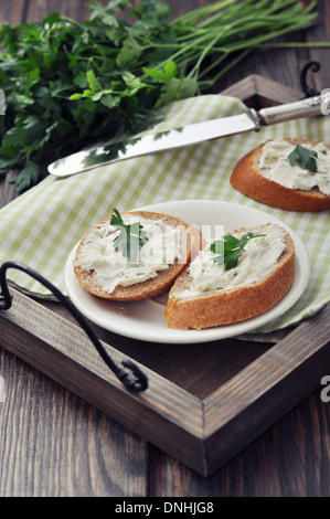 Scheibe Brot mit Frischkäse auf Vintage Tablett auf hölzernen Hintergrund Stockfoto