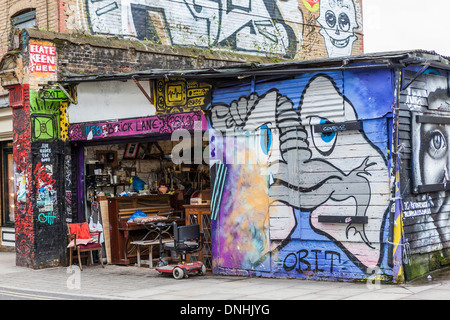 Alte Möbel, Trödel, Gebrauchtwaren Shop und Graffiti in der Brick Lane, London E1 Stockfoto