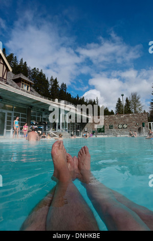 Erwachsenes paar mit ihre Beine ausgestreckt schwimmend in Banff Upper Hot Springs. Alberta, Kanada Stockfoto