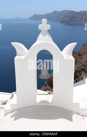 Ein Blick auf die Caldera von hinter einer traditionellen griechischen Kirche Bell auf der Insel Santorini, Griechenland Stockfoto