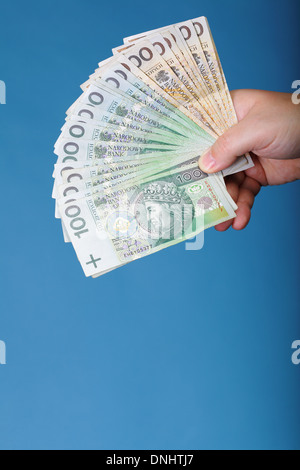 Das Unternehmer Hand mit Polnisch Geld Banknote blau Hintergrund Stockfoto