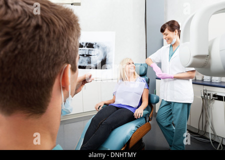 Zahnarzt untersuchen Röntgenbild mit weiblichen Assistentin Kommunikation Stockfoto