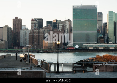 Läufer bei einem der Piers von Gantry State Park in Long Island City mit Blick auf den East River und dem UN-Hauptquartier Stockfoto