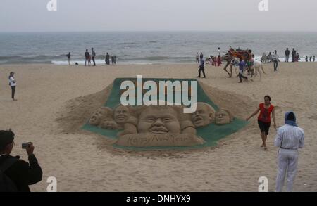 Bhubaneswar, Indien. 31. Dezember 2013. Besucher stehen in der Nähe ein neues Jahr Sandskulpturen Sudarshan Pattnaik bei Puri Strand von Sand Künstlers aus dem Golf von Bengalen, 65 km vom östlichen indischen Bundesstaat Orissa "s Hauptstadt Bhubaneswar, Indien, 30. Dezember 2013. Bildnachweis: Xinhua/Alamy Live-Nachrichten Stockfoto