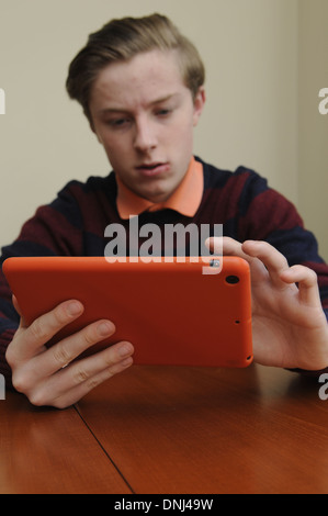 16 jähriger Junge mit einem Tabletcomputer Stockfoto