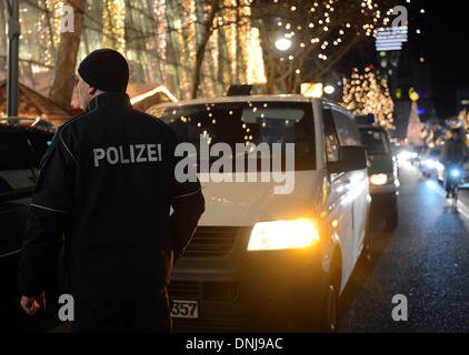 Berlin, Deutschland. 30. Dezember 2013. Polizisten stehen neben einem Geld Transport van, wie sie die Szene nach einem Raubüberfall auf Tauenzienstrasse in Berlin, Deutschland, 30. Dezember 2013 zu untersuchen. Nach ersten Erkenntnissen mindestens zwei maskierte und bewaffnete Täter Geld aus dem Transport van geplündert und entkam in ein anderes Auto. Foto: Britta Pedersen/Dpa/Alamy Live News Stockfoto