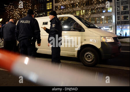 Berlin, Deutschland. 30. Dezember 2013. Polizisten stehen neben einem Geld Transport van, wie sie die Szene nach einem Raubüberfall auf Tauenzienstrasse in Berlin, Deutschland, 30. Dezember 2013 zu untersuchen. Nach ersten Erkenntnissen mindestens zwei maskierte und bewaffnete Täter Geld aus dem Transport van geplündert und entkam in ein anderes Auto. Foto: Britta Pedersen/Dpa/Alamy Live News Stockfoto