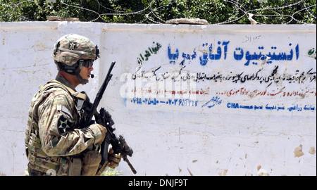 Soldat der US Army Patrouillen vorbei ein Schild in arabischer Schrift während einer Operation mit der provinzielle Rekonstruktion Team Farah 2. Juli 2013 in der Provinz Farah, Afghanistan. Stockfoto