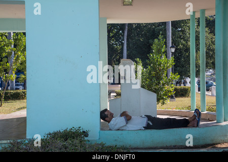 MANN SCHLÄFT VOR DER STATUE VON JOSE MARTI, CIENFUGOS, EHEMALIGE HAFENSTADT BEVÖLKERT VON DEN FRANZOSEN IM 19. JAHRHUNDERT, AUFGEFÜHRT ALS WELTKULTURERBE VON UNESCO, KUBA, KARIBIK Stockfoto