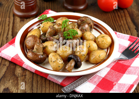 Braune Champignons mit Rosmarin-Kartoffeln und Gabel, Nahaufnahme Stockfoto