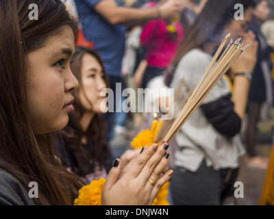 Bangkok, Thailand. 31. Dezember 2013. Frauen beten auf Vorabend des neuen Jahres am Erawan Schrein in Bangkok. Hunderttausende von Menschen packen in der Ratchaprasong Kreuzung in Bangkok für die Stadt jährliche Silvester Countdown. Viele Thais gehen die Erawan-Schrein und Wat Pathum Wanaram nahe der Kreuzung zu beten und Verdienst machen. Bildnachweis: Jack Kurtz/ZUMAPRESS.com/Alamy Live-Nachrichten Stockfoto