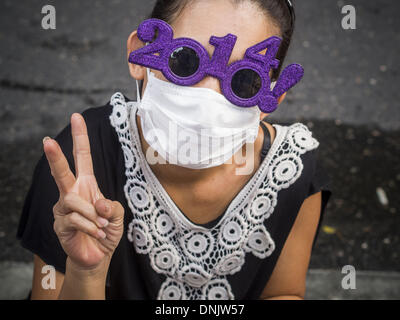 Bangkok, Thailand. 31. Dezember 2013. Eine Frau verkauft 2014 Sonnenbrille auf Vorabend des neuen Jahres in Bangkok. Hunderttausende von Menschen packen in der Ratchaprasong Kreuzung in Bangkok für die Stadt jährliche Silvester Countdown. Viele Thais gehen die Erawan-Schrein und Wat Pathum Wanaram nahe der Kreuzung zu beten und Verdienst machen. Bildnachweis: Jack Kurtz/ZUMAPRESS.com/Alamy Live-Nachrichten Stockfoto
