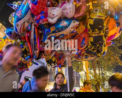 Bangkok, Thailand. 31. Dezember 2013. Ein Ballon-Verkäufer sucht Kunden auf Vorabend des neuen Jahres in Ratchaprasong Kreuzung in Bangkok. Hunderttausende von Menschen packen in der Ratchaprasong Kreuzung in Bangkok für die Stadt jährliche Silvester Countdown. Viele Thais gehen die Erawan-Schrein und Wat Pathum Wanaram nahe der Kreuzung zu beten und Verdienst machen. Bildnachweis: Jack Kurtz/ZUMAPRESS.com/Alamy Live-Nachrichten Stockfoto