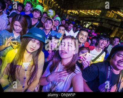 Bangkok, Thailand. 31. Dezember 2013. Menschen genießen Sie eines der Konzerte in der Silvesternacht Bangkok Ratchaprasong Kreuzung. Hunderttausende von Menschen packen in der Ratchaprasong Kreuzung in Bangkok für die Stadt jährliche Silvester Countdown. Viele Thais gehen die Erawan-Schrein und Wat Pathum Wanaram nahe der Kreuzung zu beten und Verdienst machen. Bildnachweis: Jack Kurtz/ZUMAPRESS.com/Alamy Live-Nachrichten Stockfoto