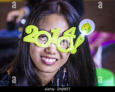 Bangkok, Thailand. 31. Dezember 2013. Eine Frau bei der Silvester-Party in Ratcharprasong-Kreuzung in Bangkok. Hunderttausende von Menschen packen in der Ratchaprasong Kreuzung in Bangkok für die Stadt jährliche Silvester Countdown. Viele Thais gehen die Erawan-Schrein und Wat Pathum Wanaram nahe der Kreuzung zu beten und Verdienst machen. Bildnachweis: Jack Kurtz/ZUMAPRESS.com/Alamy Live-Nachrichten Stockfoto