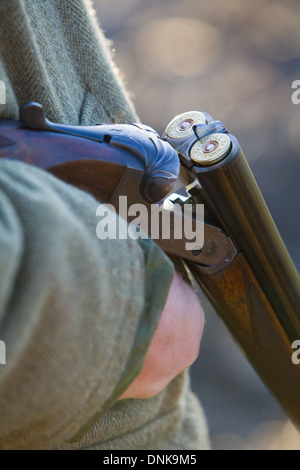 A Mann hält eine 12 Bohrung oder Schrotflinte auf einem Fasan schießen in England zu messen Stockfoto