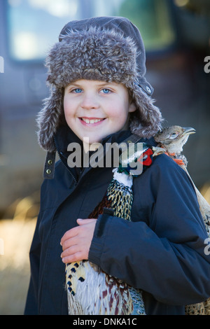 Ein kleiner Junge mit einer Klammer der Tote Fasane auf schießen ein Fasan in England Stockfoto