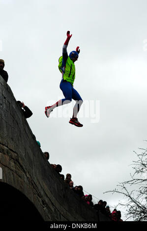 Mapleton, Derbyshire, UK. 01. January2013. Silvester-Tag-Brücke springen für wohltätige Zwecke. Teams verkleidet nahmen an der jährlichen Veranstaltung in das Dorf Mapleton Teil, beginnend mit einem Bootsrennen auf dem Fluss Dove dann ein kurzer Lauf bis zur Brücke, wo sie dann in dem Fluss Dove, sprang, schwammen zum Rand und raste bis zu der Kneipe für die Finsih, waren ein warmes Getränk und Kleider waren in Ordnung. Die Bedingungen sehr windig und schwere Regen hielt die Massen sich in diesem Jahr. Bildnachweis: Ian Francis/Alamy Live-Nachrichten Stockfoto