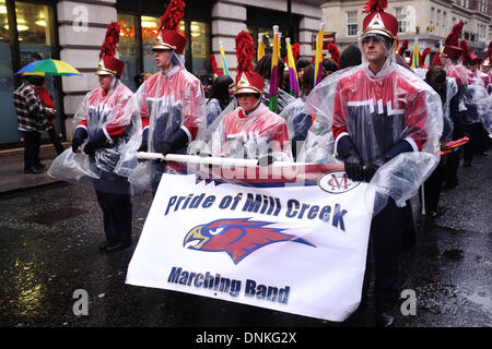 London, UK. 1. Januar 2014. Teilnehmer und Zuschauer in der New Year's Day Parade gegenüber Wind, Regen und Kälte auf den Straßen von London. Performer blieb fröhlich trotz warten bis zu zwei Stunden bei schlechtem Wetter vor ihrerseits an der parade Stockfoto