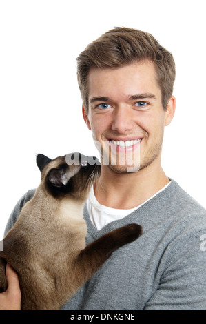 jungen Mann, der siamesische Katze hält lächelnd Stockfoto