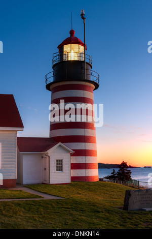 Die aufgehende Sonne erhellt den östlichen Himmel über Quoddy Narrows aus West Quoddy Head Light in Lubec Maine. Stockfoto