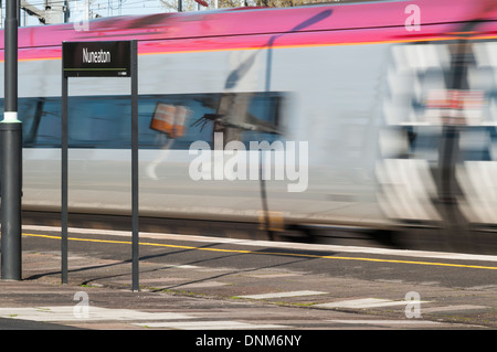 Bewegungsunschärfe von einer Jungfrau Pendolino-Zug mit hoher Geschwindigkeit durch Nuneaton Bahnhof Stockfoto