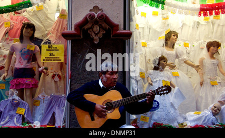 Ein Mann singt Volkslieder für Touristen vor Kleidung Shop Schaufenster 19. September 2007, in Puebla de Zaragoza, Mexiko Stockfoto